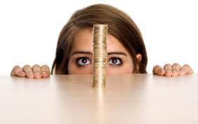 A stack of gold coins being watched intently by a young woman